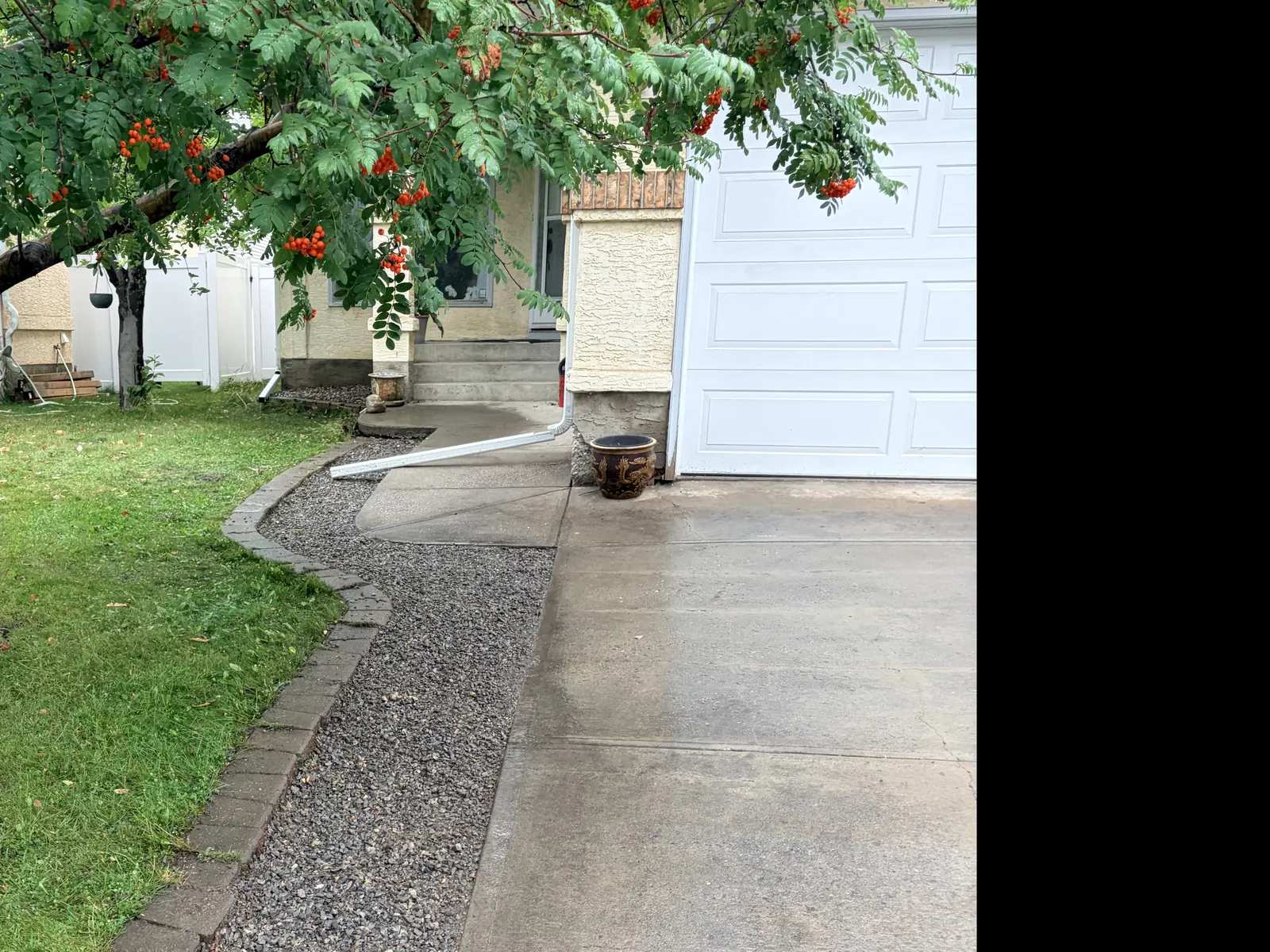 Long decorative rock border following a driveway and curved brick lawn edge