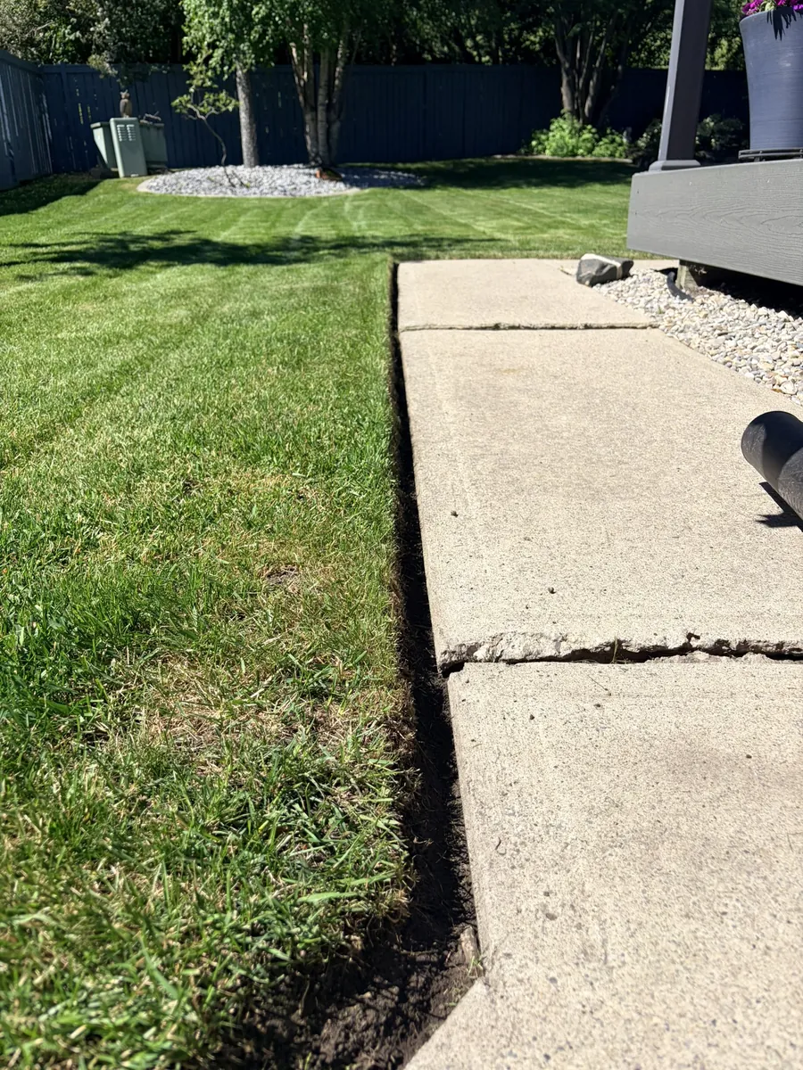 Sharp clean lawn edge along a backyard walkway in Calgary